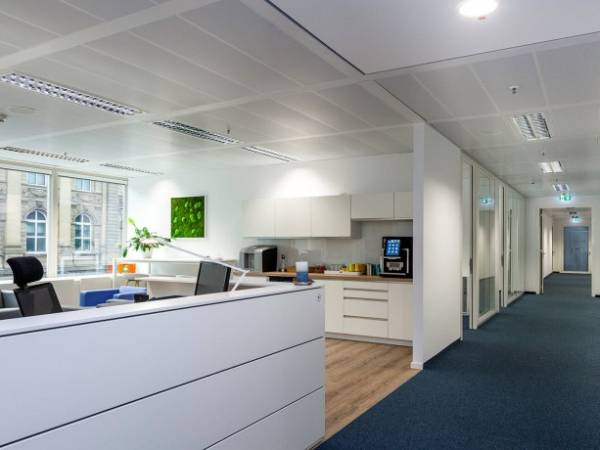 Modern gestaltete Büroräume und Arbeitsplätze mit Skyline-Blick — Bild 3